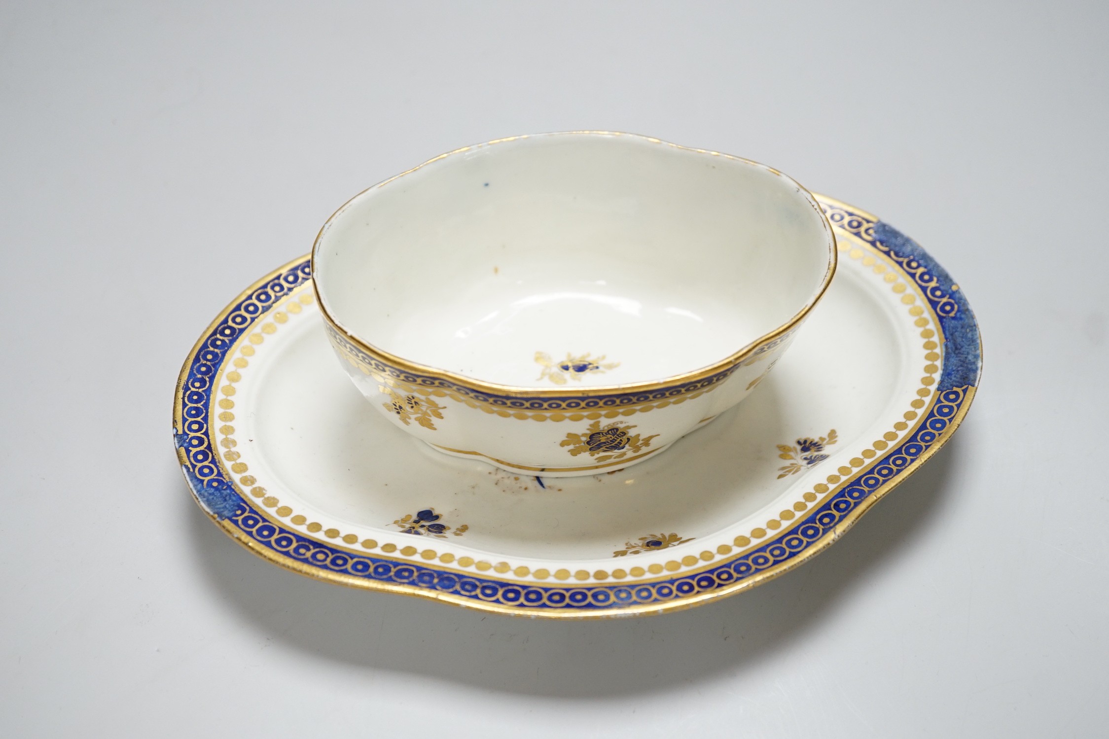 An 18th century Caughley tureen cover and stand with blue and gilt decoration, stand mis-fired to border, S mark to stand and base, stand 23cms wide